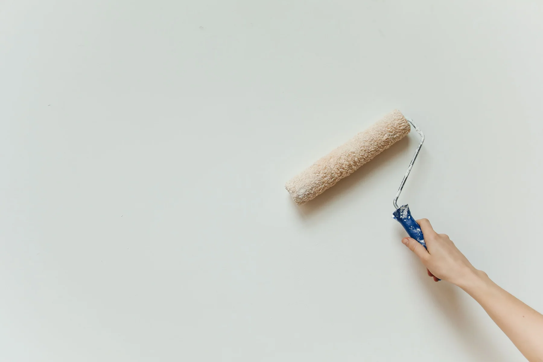 Paint roller applying a smooth coat to a wall